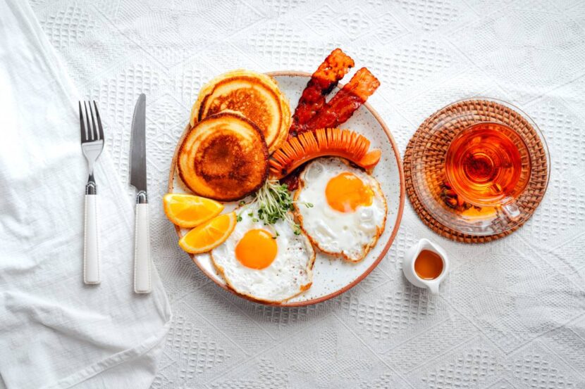 American breakfast with Pancakes, over-easy fried eggs and sausage