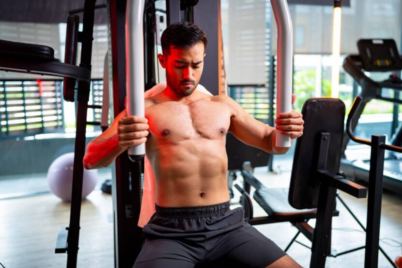 A strong Asian man is exercising to build muscle.